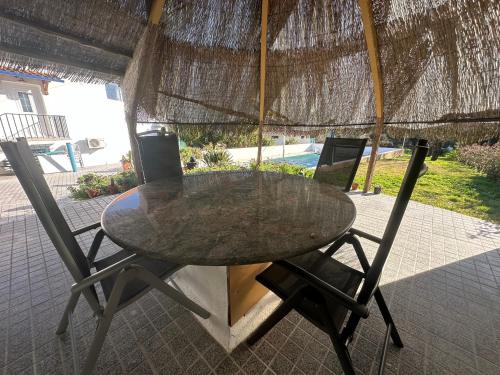 a table and chairs sitting under an umbrella at Villa Azul, Graça Portugal in Pedrógão Grande