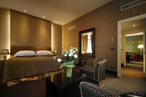 Habitación de hotel con cama y sala de estar. en Aqua Palace en Venecia