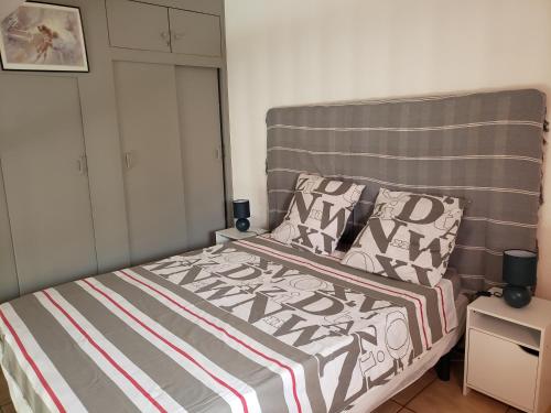 Cette petite chambre comprend un lit avec un couvre-lit rayé. dans l'établissement Confortable maison dans résidence avec piscine, 100 m de la plage, à Valras-Plage