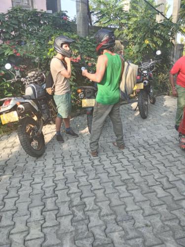 two men wearing helmets standing next to a motorcycle at Villa 95 Rangala in Kandy