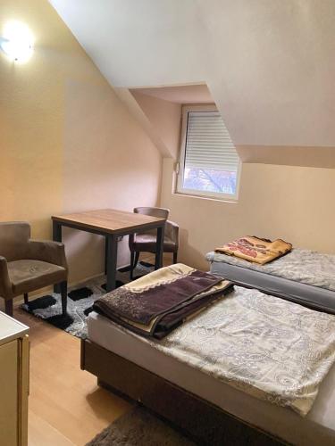 een kamer met 2 bedden, een bureau en een tafel bij Guest house Vukovic in Podgorica