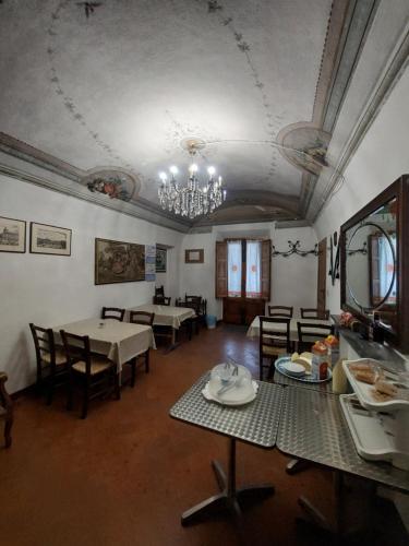 ein Esszimmer mit Tischen, Stühlen und einem Kronleuchter in der Unterkunft La Convenienza in Cascina