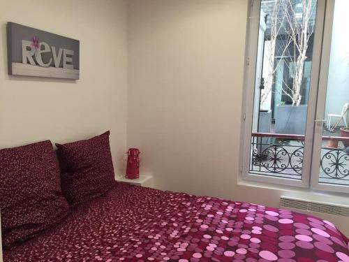 a bedroom with a bed with purple sheets and a window at Paris 5e Quartier Latin 2 pieces en Bail Mobilité in Paris