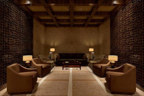 a living room with a couch and chairs and a table at The Castle Hotel, a Luxury Collection Hotel, Dalian in Dalian