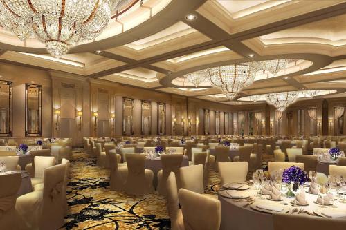 a banquet hall with white tables and chairs and chandeliers at The Castle Hotel, a Luxury Collection Hotel, Dalian in Dalian