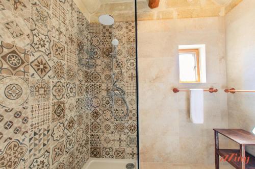 a shower with a glass door in a bathroom at Gozo Farmhouse Escape with Rustic Charm & Pool in Sannat