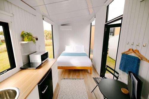 a small bedroom in a tiny house with a bed at Rimu View 1 in Hokitika