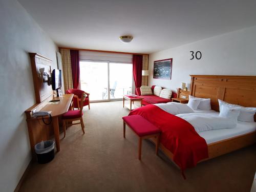 Habitación de hotel con cama, escritorio y sillas en Wander- & Wellnesshotel Nägele en Höchenschwand