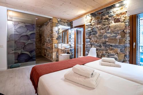 a bedroom with a large bed in a stone wall at Aristondo Boutique Pentsioa in Getaria