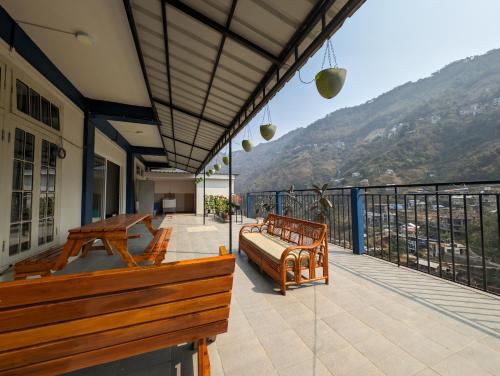 d'un balcon avec un banc et une vue sur la montagne. dans l'établissement RT Mutbu&Tukthuan, à Aizawl