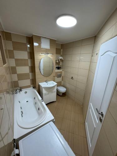 a bathroom with a tub and a sink and a toilet at David Apartament’s in Buzău