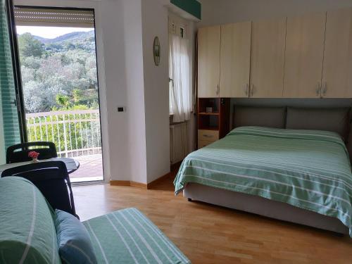 a bedroom with a bed and a large window at VentoVerde B&B in Albenga