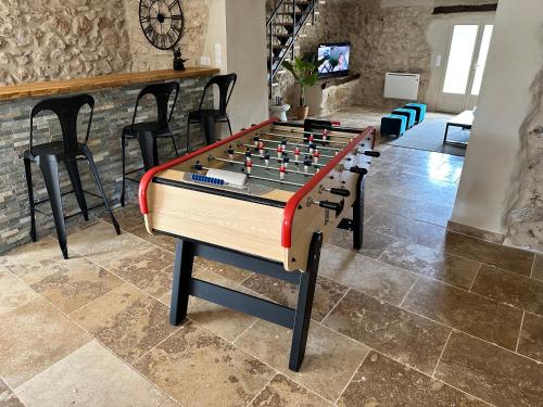 a foosball table in a living room with chairs at Les Bellangers 1 - Piscine et Jacuzzi in Artigues