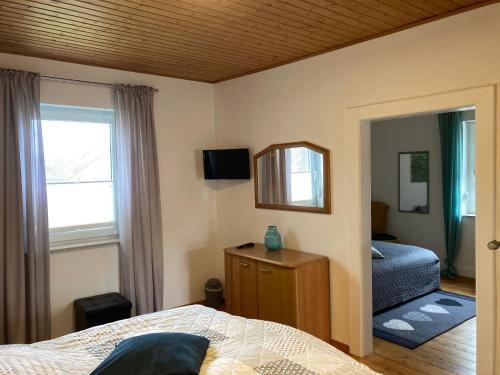 um quarto com uma cama, um espelho e uma janela em Ferienhaus Gartenblick in Brieden em Brieden