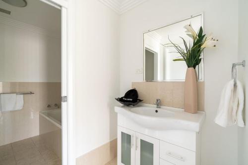 a white bathroom with a sink and a mirror at Mountain Waves in Barrack Point
