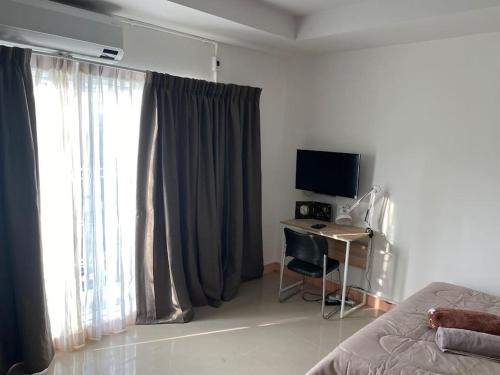 a bedroom with a bed and a desk with a computer at Superb studio Apartment in Ban Na Khua