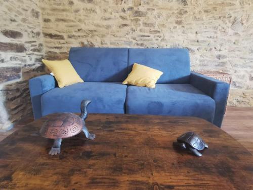 a turtle toy on a table in front of a blue couch at La grange de Pierrot in Saint-Bazile