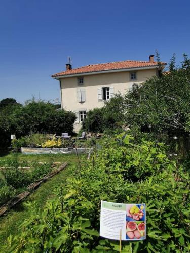 a house on a hill with a sign in the bushes at La grange de Pierrot in Saint-Bazile