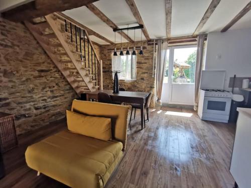 a living room with a couch and a table and a desk at La grange de Pierrot in Saint-Bazile