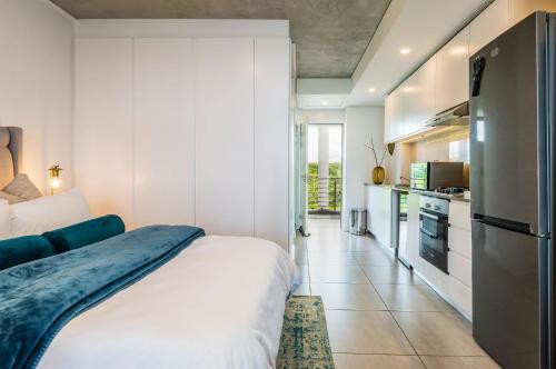a bedroom with a large bed and a kitchen at Coral Point Sibaya Luxury Apartment in Sibaya