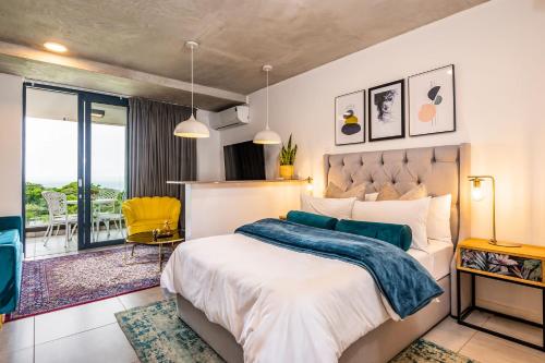 ein Schlafzimmer mit einem Bett und einem Balkon in der Unterkunft Coral Point Sibaya Luxury Apartment in Sibaya