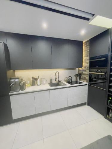 a kitchen with white cabinets and a sink at Blue room in Żory