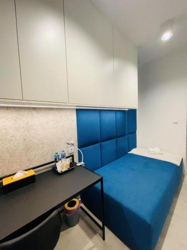 een kamer met een blauw bed en een bureau bij Blue room in Żory