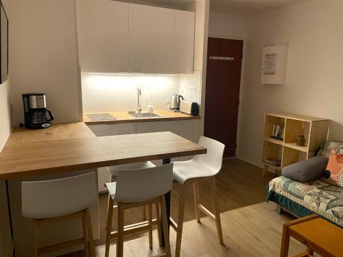 une cuisine avec une table et des chaises dans une pièce dans l'établissement Cosy, fully renovated 2-room apartment with sea view, à Villers-sur-Mer