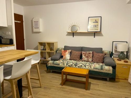 un salon avec un canapé et une table dans l'établissement Cosy, fully renovated 2-room apartment with sea view, à Villers-sur-Mer