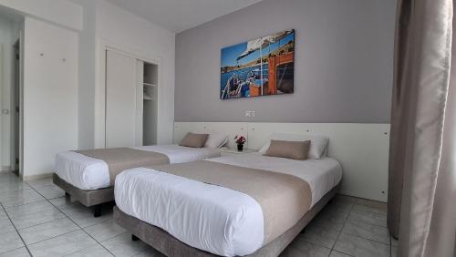 two beds in a hotel room with a picture on the wall at LEVEL Mallorca - Living in Palma de Mallorca