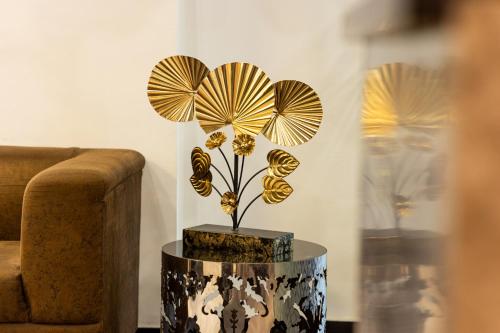 a vase with a flower on a table next to a couch at Hotel Cosmo Near BLK Hospital Karol Bagh in New Delhi