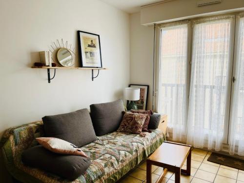 un salon avec un canapé et une fenêtre dans l'établissement Cosy, fully renovated 2-room apartment with sea view, à Villers-sur-Mer