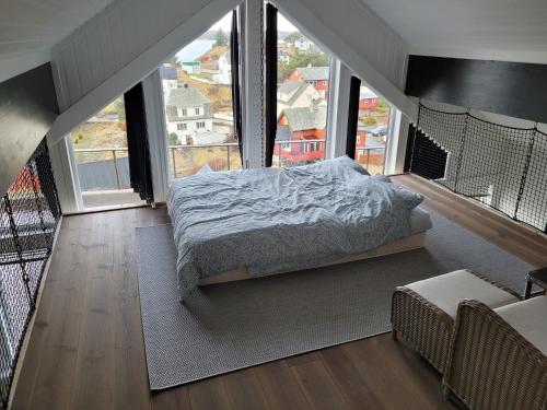 ein Schlafzimmer mit einem Bett in einem Zimmer mit großen Fenstern in der Unterkunft beautiful villa with seaview and sunny in Askøy