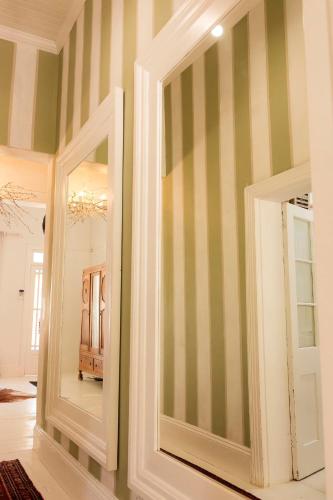 two mirrors in a room with green and white stripes at Boutique Guesthouse Hanover in Hanover