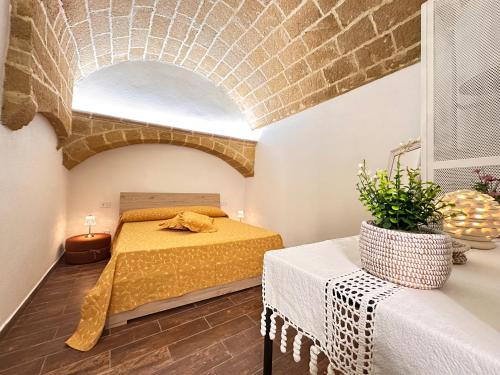 1 dormitorio con cama y pared de ladrillo en Agnese Experience Suite en Gallipoli