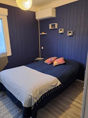una camera blu con un letto con due cuscini di maison de vacances SOREDE 5 KMS ARGELES SUR MER a Sorède