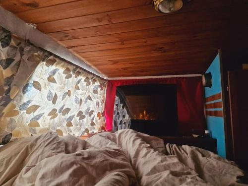 a bed in a bedroom with a wooden ceiling at Bateau / Vedette Hollandaise Ramonville-Saint-Agne in Ramonville-Saint-Agne