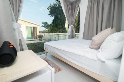 um quarto com uma cama branca e uma janela em บ้านสายน้ำ วิลล่า em Chiang Khan
