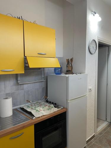 a kitchen with yellow cabinets and a white refrigerator at A&d in Carrao