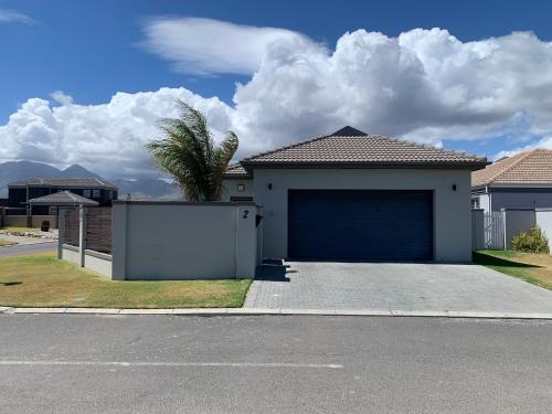 a garage in a house with a palm tree at Family Friendly Home in Gordonʼs Bay
