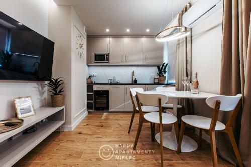 a kitchen and dining room with a table and chairs at Happy Gold - Happy Apartamenty Mielec in Mielec