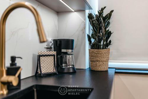a kitchen counter with a coffee maker and a plant at Happy Gold - ApartamentyHappy pl in Mielec