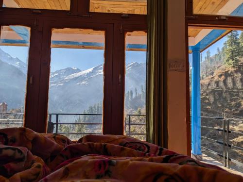 Łóżko w pokoju z widokiem na góry w obiekcie Vigyan Guest House Tosh w mieście Tosh