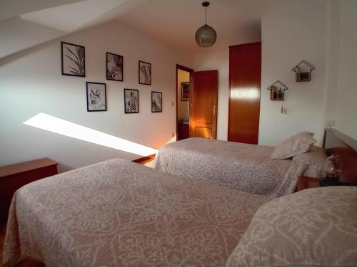 a room with two beds and a light on the wall at Dúplex Saja in San Vicente de la Barquera