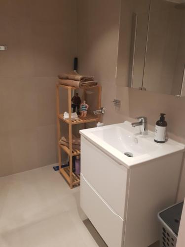 een witte badkamer met een wastafel en een plank bij Ny leilighet i Tromsøs nye bydel in Tromsø