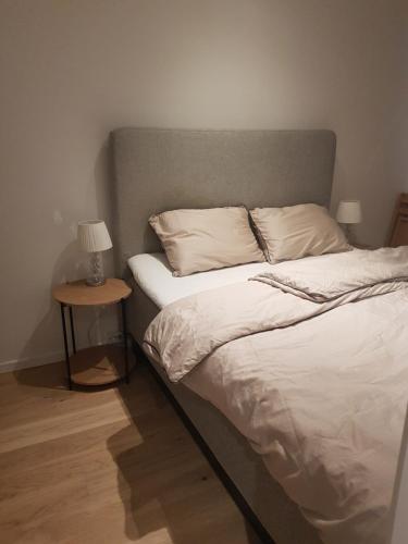 een bed in een kamer met een nachtkastje naast een bed sidx sidx sidx bij Ny leilighet i Tromsøs nye bydel in Tromsø