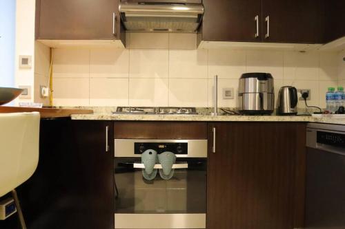 a kitchen with a stove with a towel on the oven at 2BR Bright Coastal Haven - Al Reem Escape in Abu Dhabi