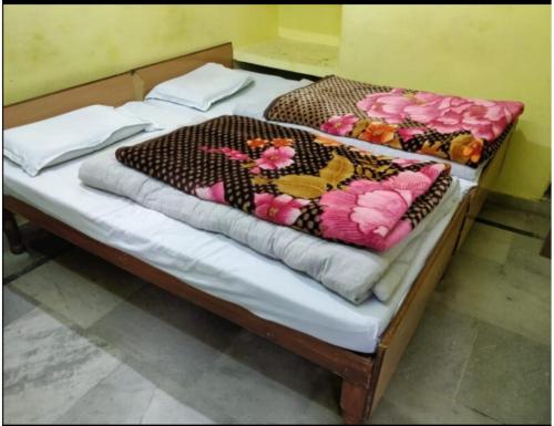 a bed with a wooden frame with flowers on it at Hotel Chandradeep, Joshimath in Joshīmath