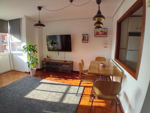 a living room with a table and a television at Dúplex Saja in San Vicente de la Barquera