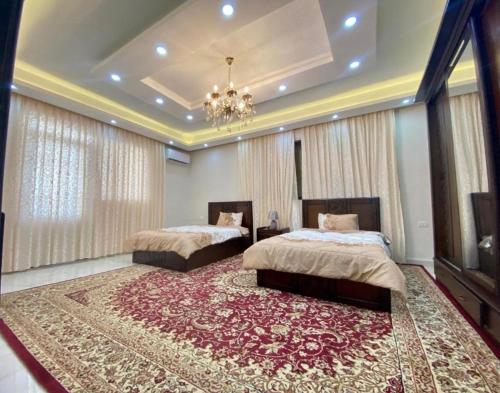 a bedroom with two beds and a large rug at Luxury Apartment 3BR near 7th circle in Amman